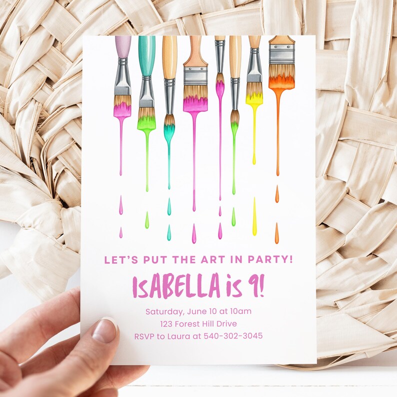Op de afbeelding: Een witte uitnodigingskaart met kleurrijke penselen en druipende verf. De tekst luidt "LET'S PUT THE ART IN PARTY! ISABELLA is 9!" met evenementdetails. De kaart wordt door een hand vastgehouden.