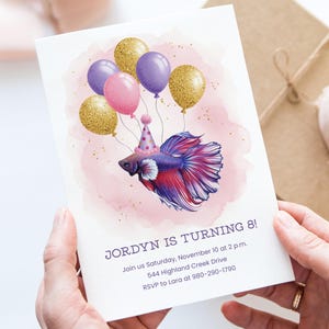 May include: Birthday invitation featuring a watercolor betta fish wearing a party hat and holding balloons. The invitation reads "Jordyn is turning 8!" with event details. The design includes pink, purple, and gold colors.