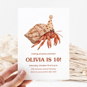 Puede incluir: Una invitaci&oacute;n de cumplea&ntilde;os con una ilustraci&oacute;n en acuarela de un cangrejo ermita&ntilde;o con un gorro de fiesta. La invitaci&oacute;n dice "Calling all party animals! OLIVIA IS 10!" con detalles del evento. El cangrejo es marr&oacute;n y naranja.