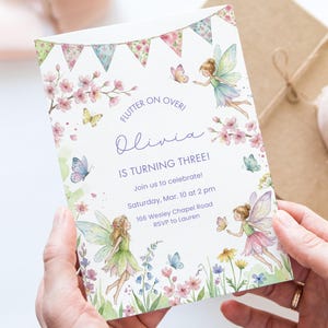 May include: A birthday invitation with a fairy theme, featuring illustrations of fairies, butterflies, and flowers. The text reads "Flutter on Over! Olivia is Turning Three!" with event details. The design includes a banner of floral and pastel flags.
