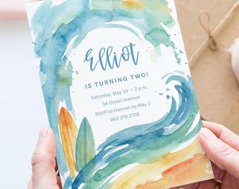 May include: A watercolor-style invitation with a beach theme. The invitation features the name "Elliot" and the text "IS TURNING TWO!" in blue script. The design includes a blue wave, surfboards, and event details.