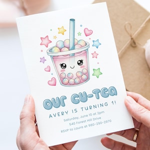 May include: A birthday invitation featuring a cute cartoon bubble tea cup with a smiling face, surrounded by stars and hearts. The text "Our Cu-Tea Avery is Turning 1!" is displayed in blue, along with event details.