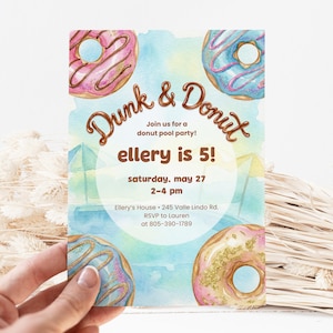 Puede incluir: Una invitación en acuarela para una fiesta en la piscina de donas. La invitación presenta el texto "Dunk & Donut" y "ellery is 5!" con imágenes de donas. También se incluyen la fecha y la hora. El fondo es un lavado de acuarela azul y amarillo.