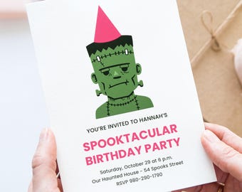 May include: A white invitation card with a green Frankenstein monster illustration wearing a pink party hat. The text reads "YOU'RE INVITED TO HANNAH'S SPOOKTACULAR BIRTHDAY PARTY" with event details. The card is held by a person.