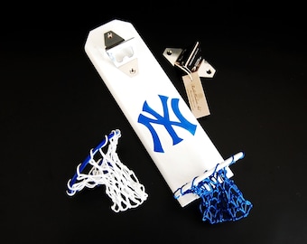 May include: White wooden bottle opener with a blue and white New York Yankees logo, a bottle opener, and two blue and white basketball nets.