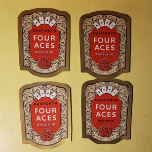 May include: Four vintage wine labels with gold trim and a red background. The labels feature the text "Danforth Four Aces" and the words "White Wine" or "Red Wine".