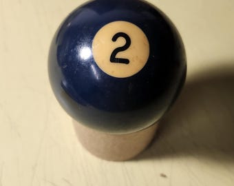 May include: A blue billiard ball with a white number "2" on it.