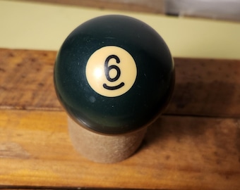 May include: A green billiard ball with a white number "6" on it.