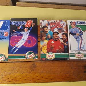Könnte beinhalten: Vier Montreal Expos Baseball-Team-Kalender aus den Jahren 1986, 1988 und 1990. Jeder Kalender zeigt einen anderen Spieler und den Text "Calendrier Officiel" und "Expos 50".