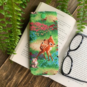 Puede incluir: Una funda para gafas de tela verde y marr&oacute;n con cierre de presi&oacute;n. La funda presenta un estampado colorido de Bambi y Tambor de la pel&iacute;cula de Disney Bambi.