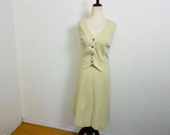 Beige preppy kjolkostym i polyester från 1970-talet med väst och pennkjol. Mellanstor.