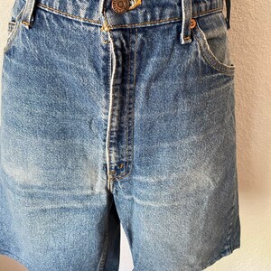 May include: Light blue denim shorts with a button fly and a faded look. The shorts have a classic five-pocket design.