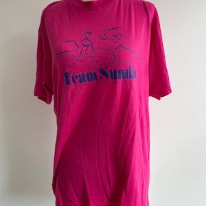 Pink skiing/biking tee. Hanes Brand vintage 1980s tee. Pink and blue. All cotton. Team Sunday. Size L. Classic vintage groovy sportswear.