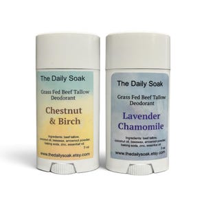 May include: Two white plastic deodorant containers with labels. The left label is yellow with text Chestnut & Birch. The right label is blue with text Lavender Chamomile. Both labels state The Daily Soak, Grass Fed Beef Tallow Deodorant, 3 oz.