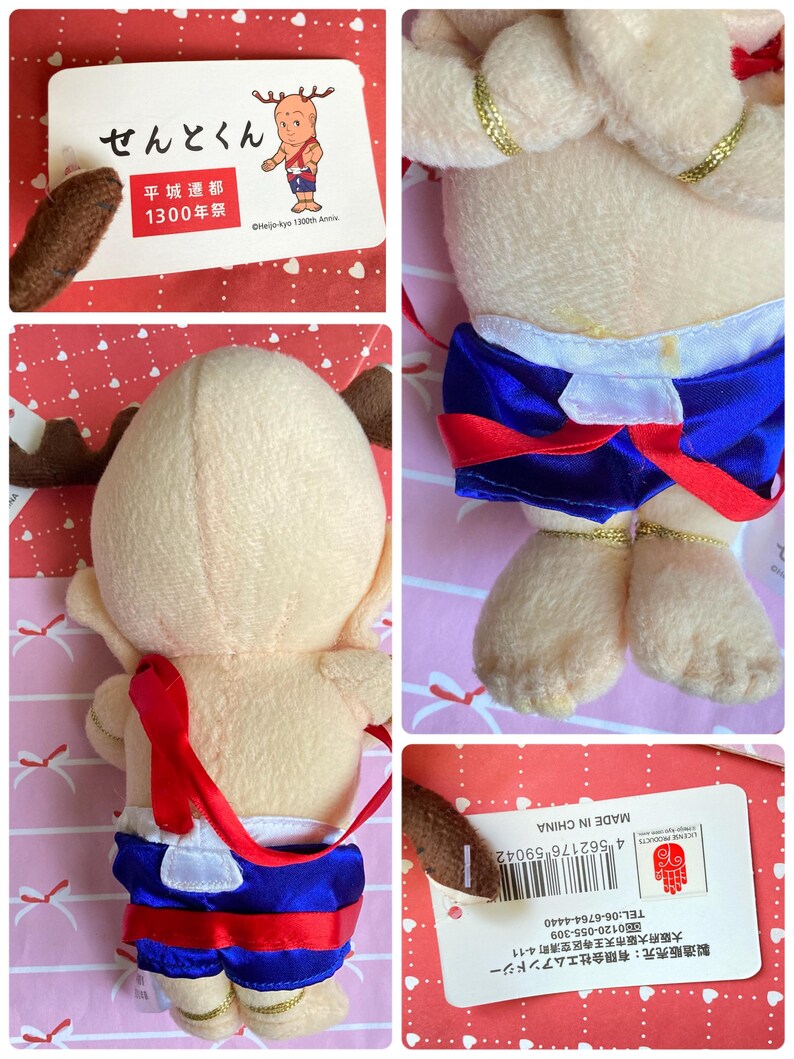 May include: A plush doll of a cartoon character with a light tan body, brown antlers, and blue shorts with red trim. The doll has gold accents and a red strap. A tag with Japanese text and the words "MADE IN CHINA" is attached.