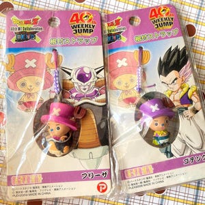 以下が含まれることがあります： ワンピースのトニートニー・チョッパーなどのキャラクターが描かれた、2つのパッケージされたアニメキャラクターのストラップ。パッケージには日本語のテキストと「Weekly Jump」のロゴが入っています。ストラップは透明なプラスチック製です。