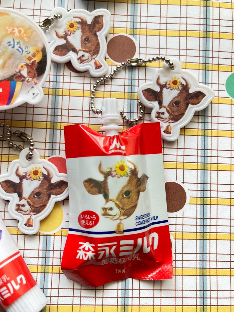 May include: A white ceramic mug with a black handle and the text "But First, Coffee" in a black, bold font. The mug is on a white surface. The mug is approximately 4 inches tall.