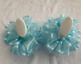 May include: Two light blue tulle and satin hair bows with white plastic clips. The bows are ruffled and layered.