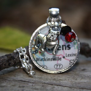 May include: Silver charm necklace with a bulldog charm, red and black beads, and a map of Watkinsville, Georgia. The map shows the town name, the number 77, and the words "Lexing" and "ens".