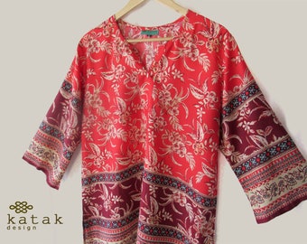 May include: A red and burgundy floral print top with a V-neck and 3/4 sleeves. The sleeves have a burgundy and white patterned trim.