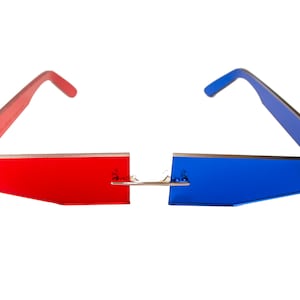 Puede incluir: Gafas 3D rojas y azules con un puente plateado. Las gafas tienen una forma rectangular y est&aacute;n hechas de pl&aacute;stico.