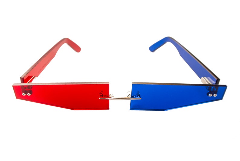 Puede incluir: Gafas 3D rojas y azules con un puente plateado. Las gafas tienen una forma rectangular y est&aacute;n hechas de pl&aacute;stico.