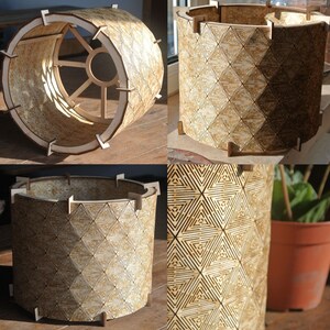 May include: A wooden lampshade with a geometric pattern. The lampshade is made of thin strips of wood that are joined together to create a cylindrical shape. The pattern is made up of triangles that are arranged in a repeating pattern. The lampshade is a light brown color.