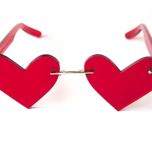 May include: Red heart-shaped sunglasses with a silver bridge.