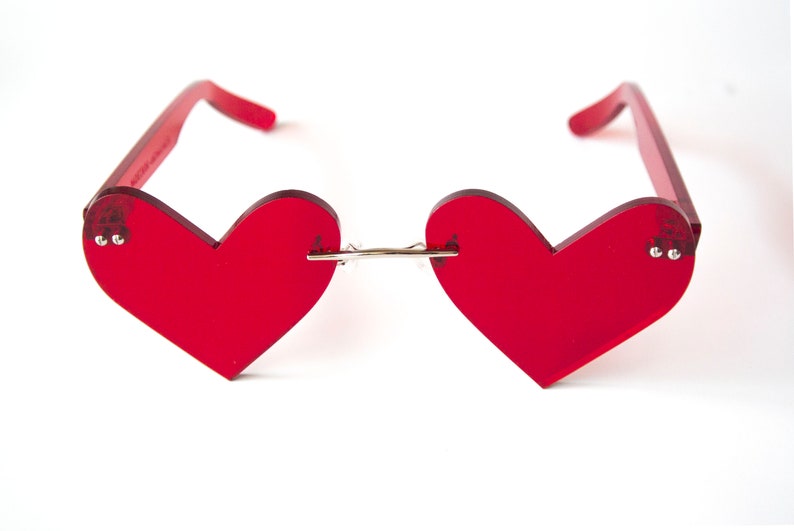 May include: Red heart-shaped sunglasses with a silver bridge.