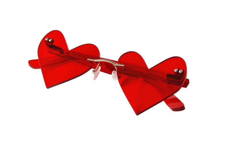 May include: Red heart-shaped sunglasses with a silver metal bridge.
