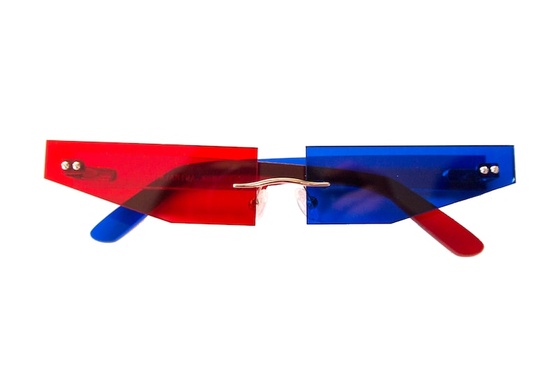 Puede incluir: Gafas de sol de pl&aacute;stico rojo y azul con un puente de metal delgado. Las gafas tienen una forma geom&eacute;trica con bordes angulados.
