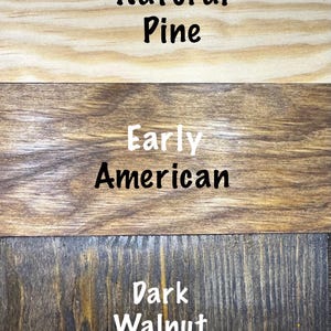 Puede incluir: Primer plano de tres muestras de madera con diferentes acabados. La muestra superior es Natural Pine, la del medio Early American y la inferior Dark Walnut. Cada muestra tiene el nombre del acabado en texto blanco.