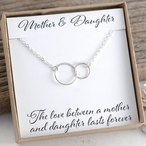May include: A silver necklace with two interlocking circles, presented in a box with the text "Mother & Daughter" and "The love between a mother and daughter lasts forever".