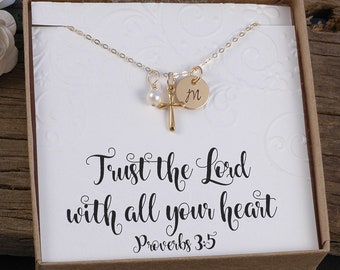 May include: Gold necklace with a cross charm, a pearl charm, and a personalized initial charm. The necklace is in a box with a white card that says "Trust the Lord with all your heart Proverbs 3:5".
