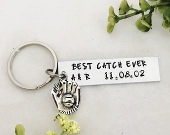 Puede incluir: Llavero de plata con un dije de guante de béisbol y una etiqueta que dice "BEST CATCH EVER A&R 11.08.02"