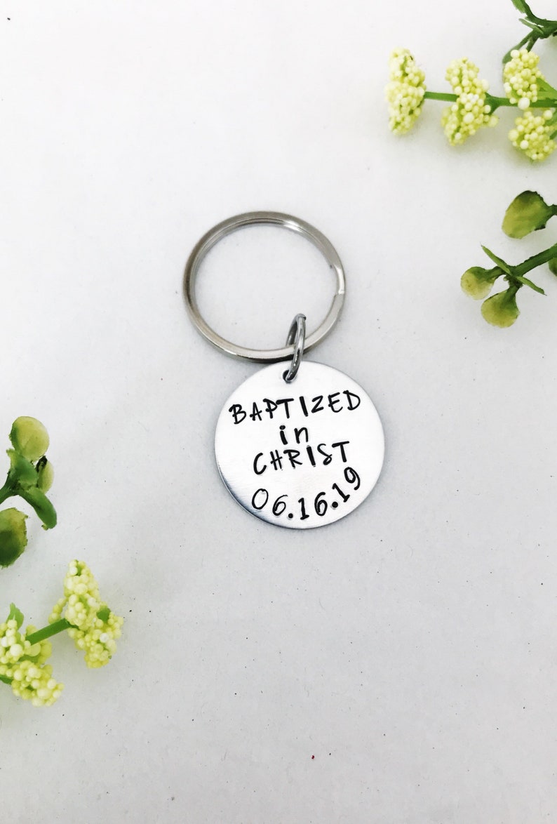 May include: Silver keyring with a round tag that says "Baptized in Christ 06.16.19".