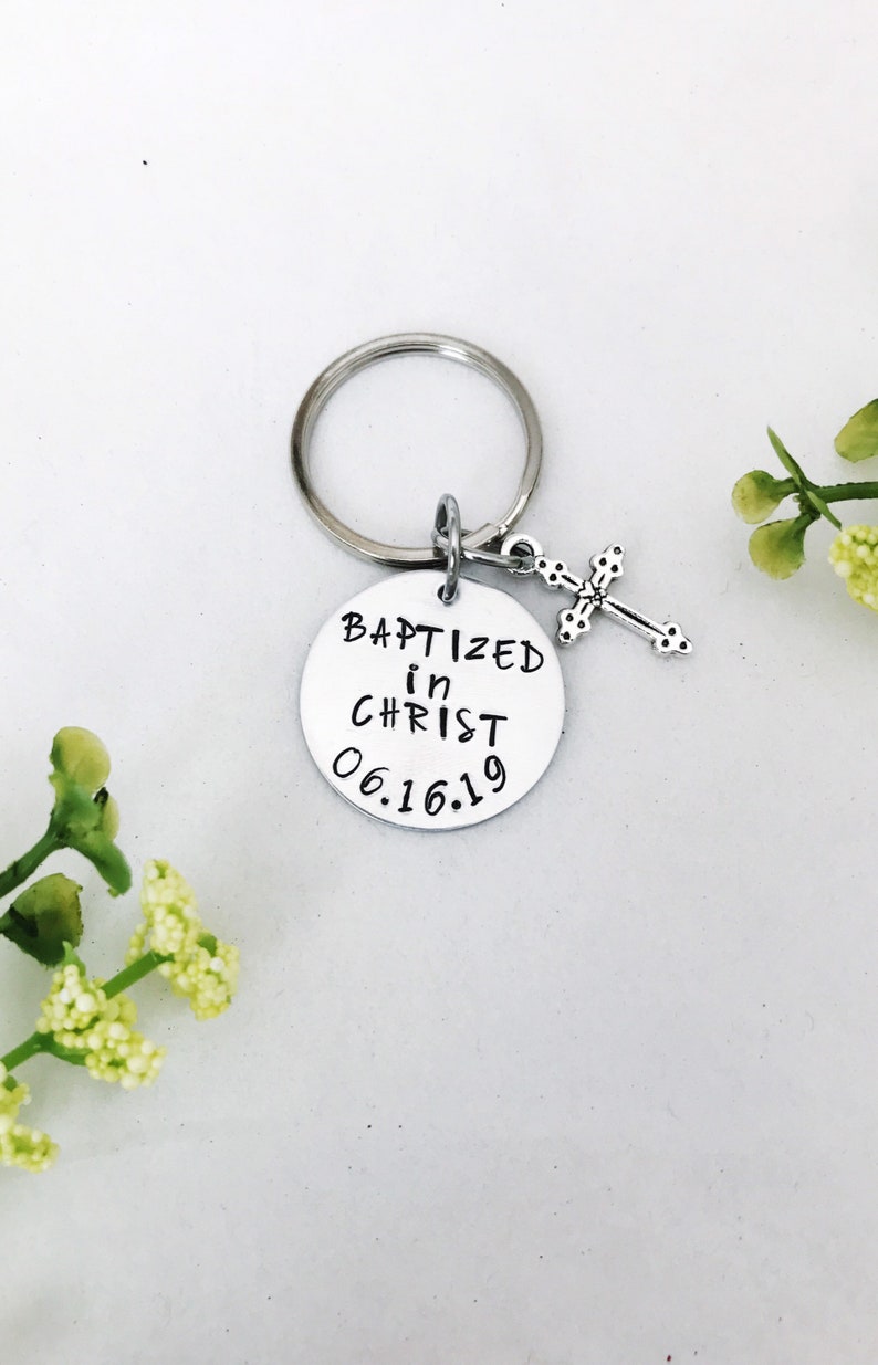 May include: Silver keyring with a round charm that says "Baptized in Christ 06.16.19" and a small silver cross charm.