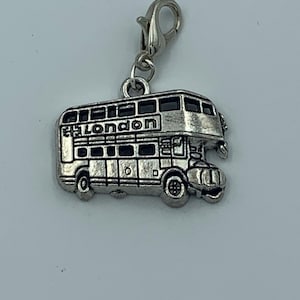 Könnte beinhalten: Silberner Anhänger in Form eines Doppeldeckerbusses mit dem Wort "London" an der Seite.
