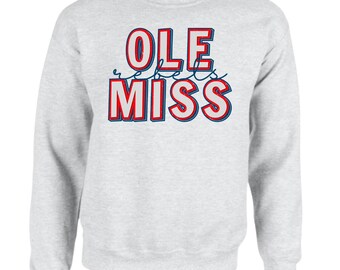 May include: Gray sweatshirt with the words "Ole Miss" in red and blue lettering with a white outline. The word "Ole" is stacked above the word "Miss" and the words "Rebels" are written in cursive in between the two words.