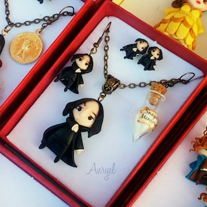 May include: A set of handmade jewelry featuring characters from popular fantasy books and movies. The jewelry includes necklaces, earrings, and charms. The charms are made of polymer clay and are painted in various colors. The necklaces and earrings are made of silver chain and have a vintage look.