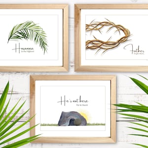 May include: Three framed prints with religious themes. The first print features a palm branch with the text "Hosanna in the Highest!" The second print features a crown of thorns with the text "Father forgive them." The third print features a stone tomb with the text "He's not here. He is risen!"