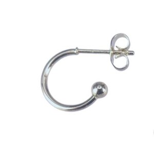 May include: A single silver-colored earring with a curved design. The earring features a small ball at the end of the curve and a post with a butterfly clasp for secure wear. The earring is set against a white background.