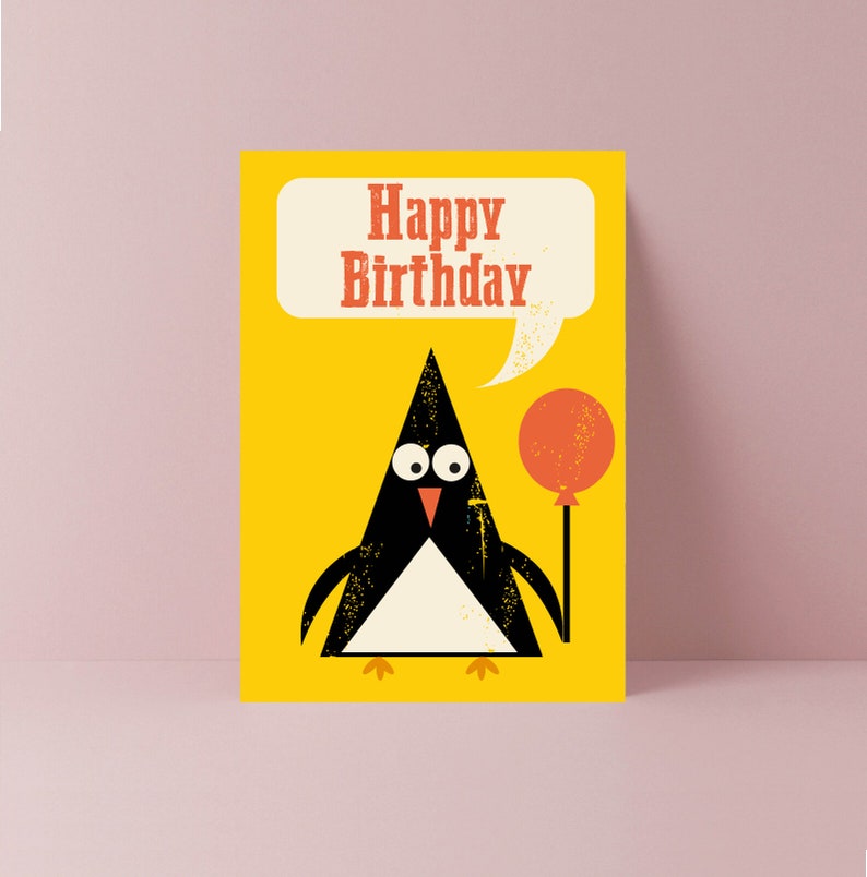 Op de afbeelding: Een gele kaart met een zwart-witte pingu&iuml;n die een rode ballon vasthoudt. De kaart zegt "Happy Birthday" in een spreekballon.