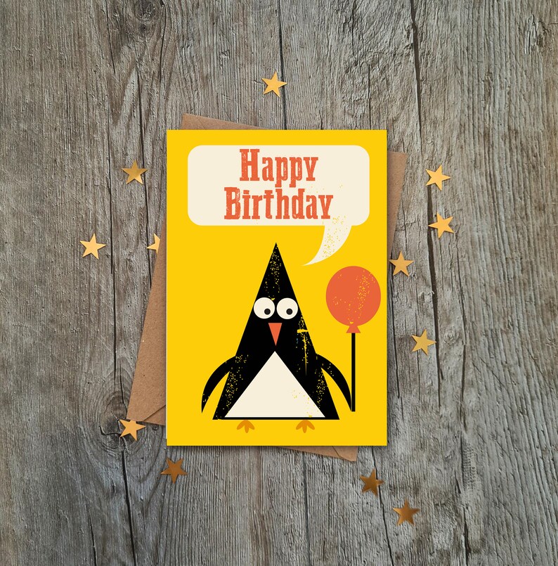 Op de afbeelding: Een gele verjaardagskaart met een pingu&iuml;n die een rode ballon vasthoudt. De kaart zegt "Happy Birthday" in een spreekballon.