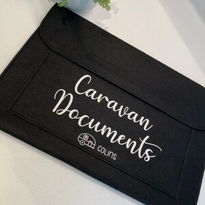 May include: Black felt folder with the text "Caravan Documents" and a small caravan icon. The text "COLINS" is below the icon.