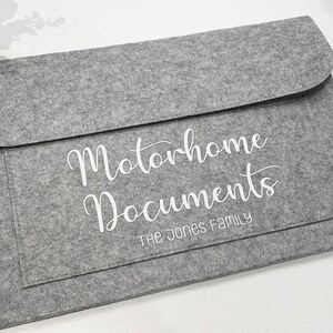 May include: Gray felt folder with the text "Motorhome Documents" and "The Jones Family" in white lettering.