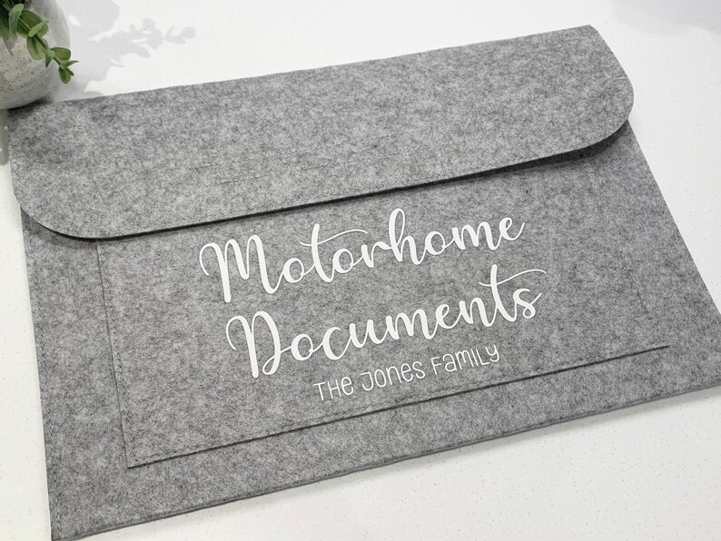 May include: Gray felt folder with the text "Motorhome Documents" and "The Jones Family" in white lettering.