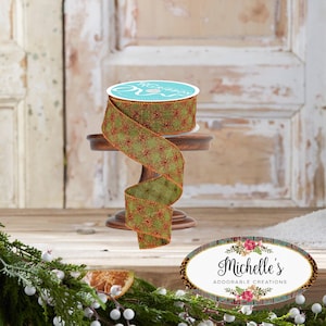May include: A spool of green and red patterned ribbon sits on a small wooden stand. The ribbon has a diamond pattern with red accents and a red border. The spool has the text "YARD RIBBON" on the top. The image also includes the text "Michelle's Adorable Creations".