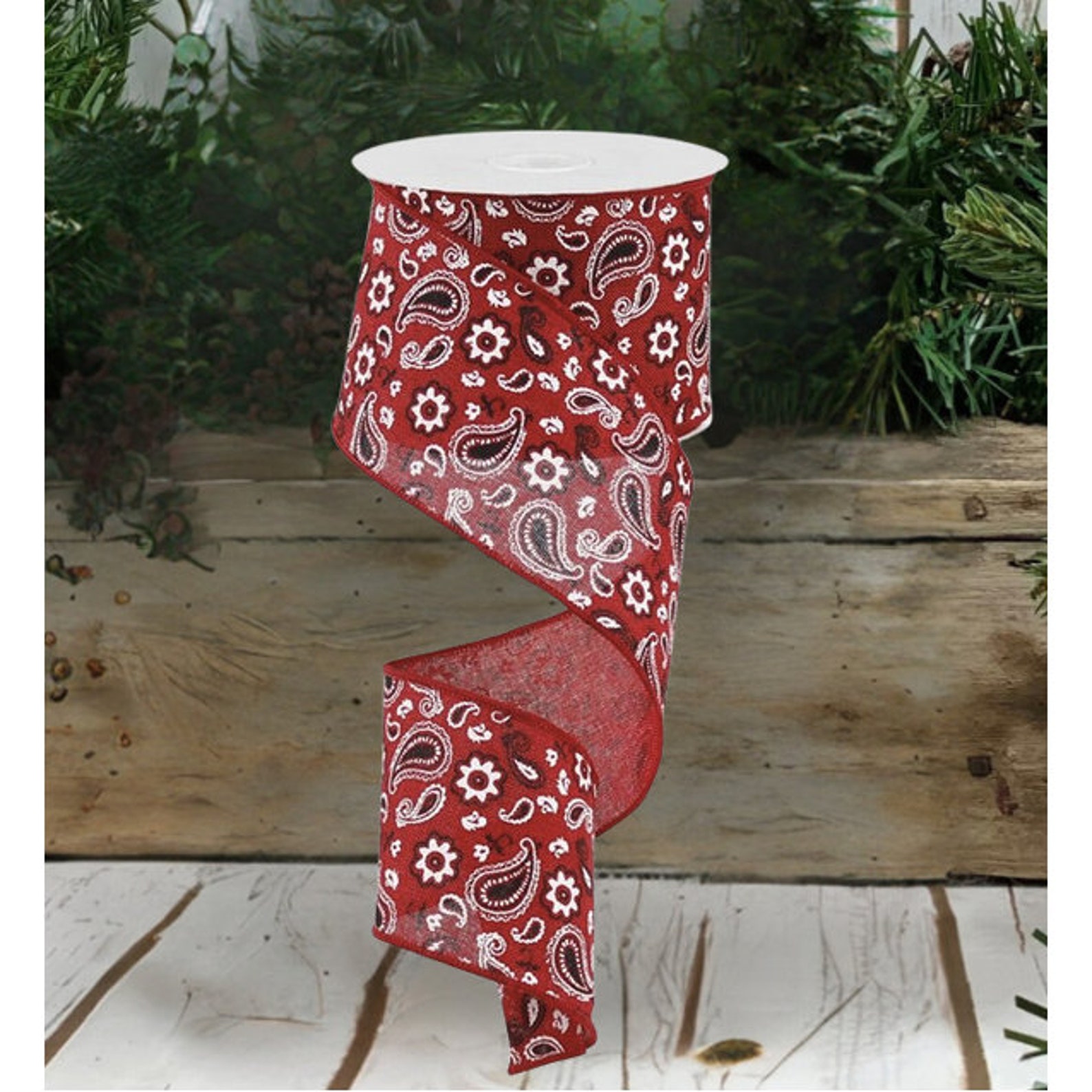 Red bandana print ribbon on a spool, showcasing its vibrant and colorful pattern