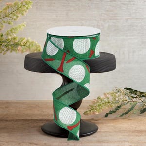 Può includere: Un rotolo di nastro verde con un motivo a palline da golf bianche e tee rossi. Il nastro è esposto su un supporto nero. Il nastro a tema golf è adatto a vari progetti creativi e confezioni regalo.